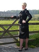 Sexy office girl Larissa takes a walk in the countryside after a day in the office still wearing her suit and shiny black high heels